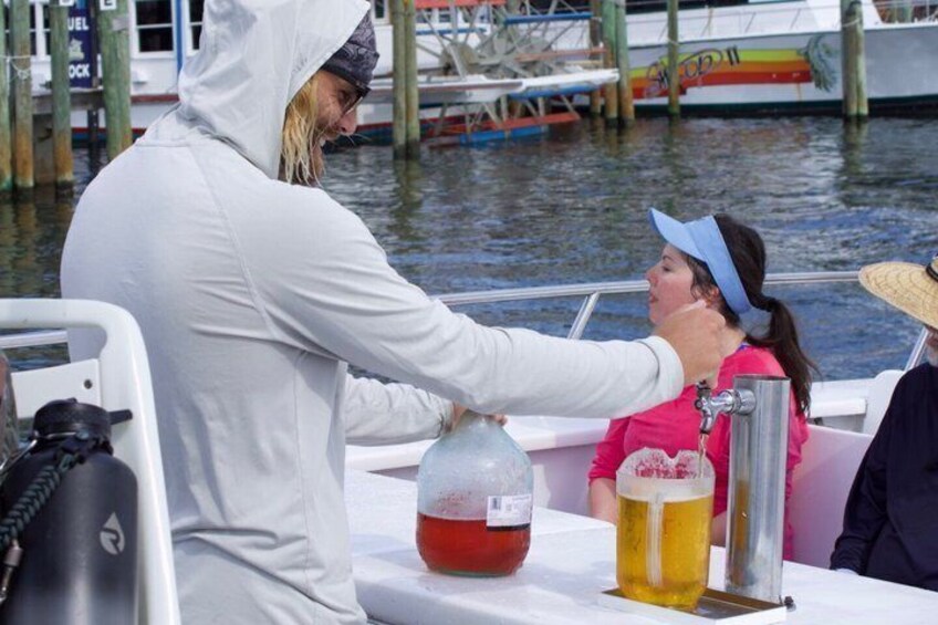 A person pouring a drink into a glass on a boat. 5