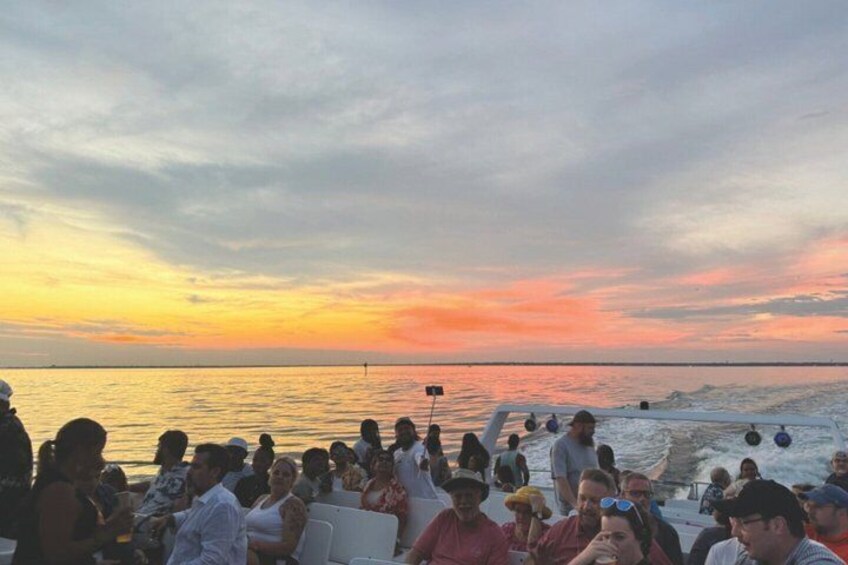 A group of people on a boat at sunset. 3