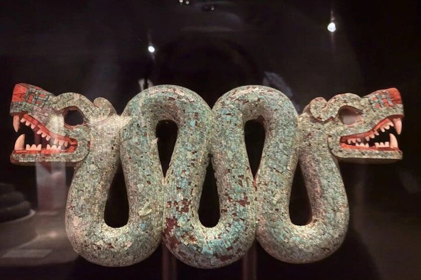 Un'imponente scultura di un serpente finemente intagliato, con bocche spalancate e squame dettagliate. 1