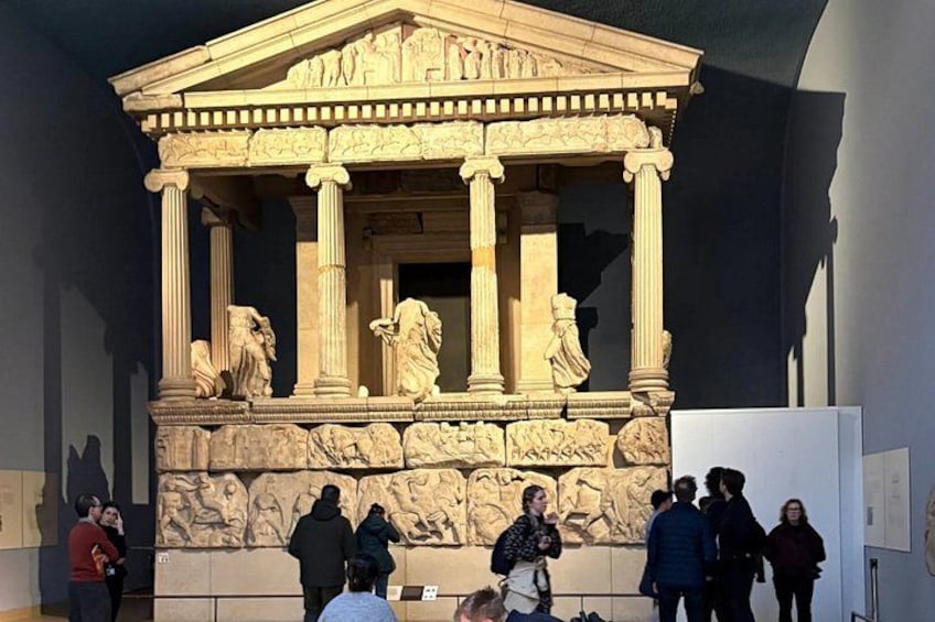 Un edificio neoclassico con colonne e decorazioni elaborate, circondato da visitatori. 3