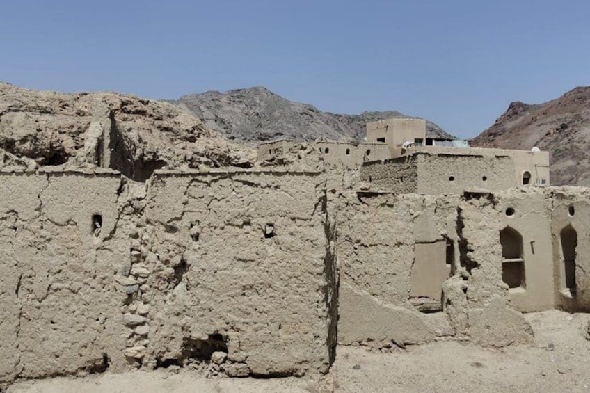 Ancient ruins with arched doorways and a mountainous backdrop. 4