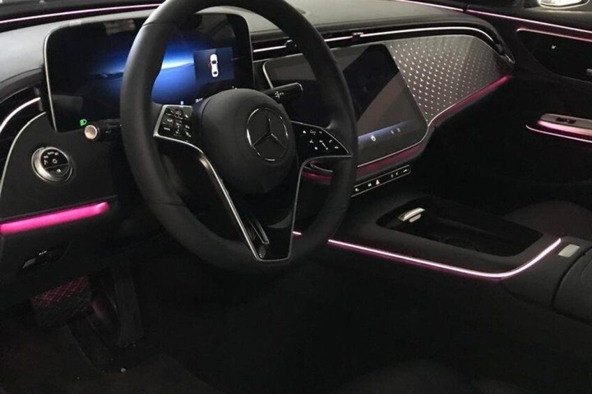 Ein modernes Auto-Interieur mit digitaler Instrumententafel, Lenkrad und Ambientebeleuchtung. 2