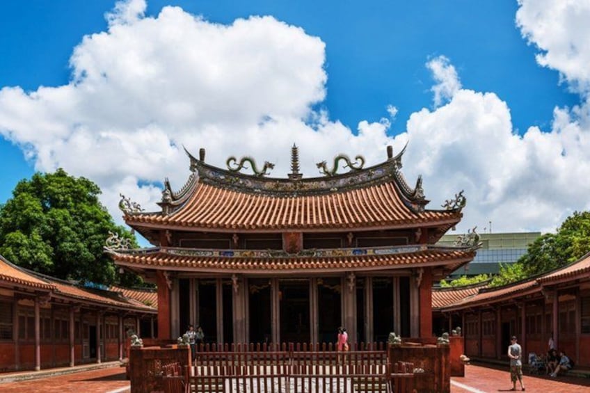 A traditional Chinese building with ornate architecture, a clear blue sky, and lush greenery in the background. 4