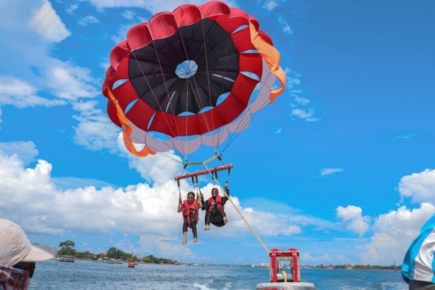 Actividad de parasailing con un paracaídas rojo y negro sobre el agua. 2