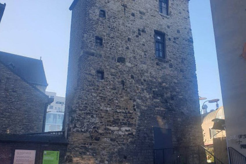A tall stone tower with multiple windows and a gate at the base. 4