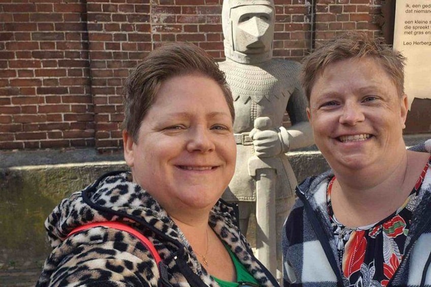 Two people standing in front of a statue. 5