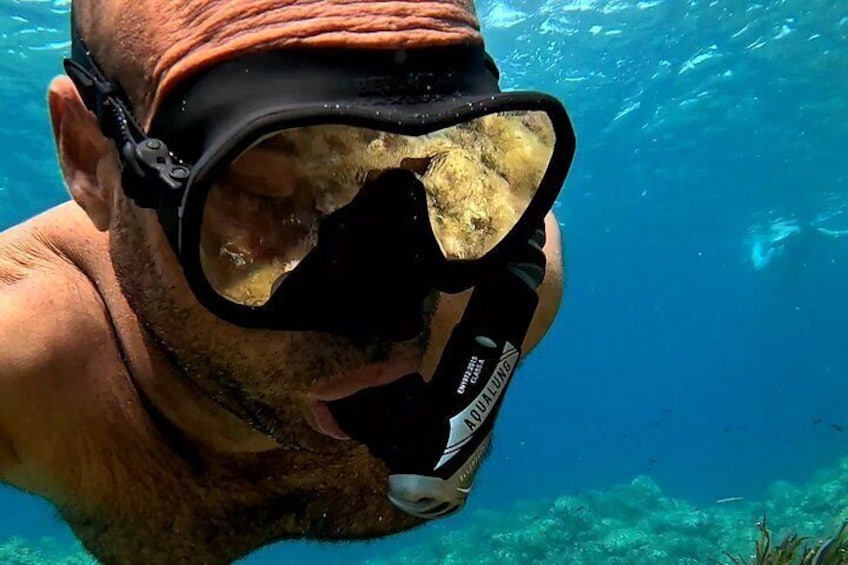 A person underwater with a snorkel and mask, surrounded by clear blue water. 2