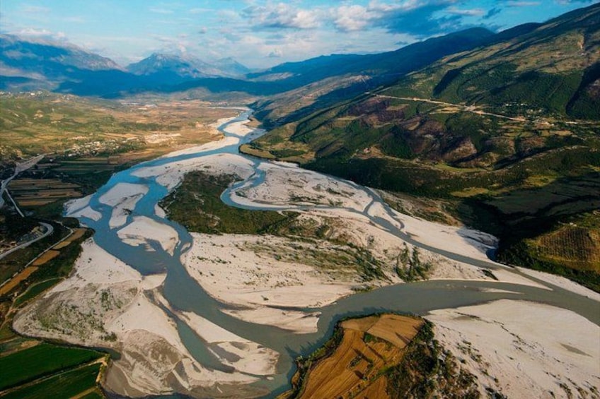 A river winding through a mountainous landscape with snow-capped peaks in the background. 3