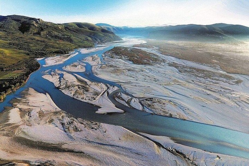 A river winding through a valley with distant mountains. 4