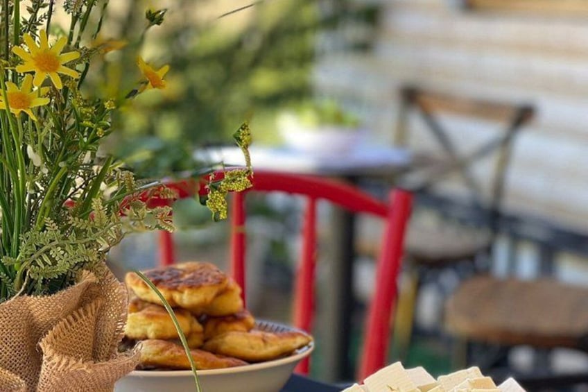 A basket of pastries, a red chair, and a vase with flowers. 2