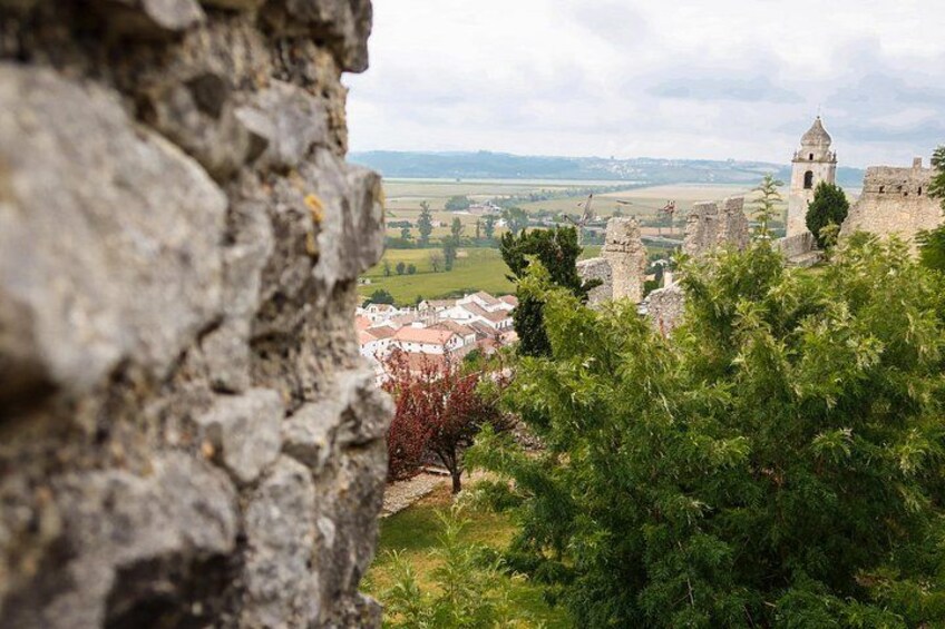 A stone wall, a tower, and a village in the background. 5