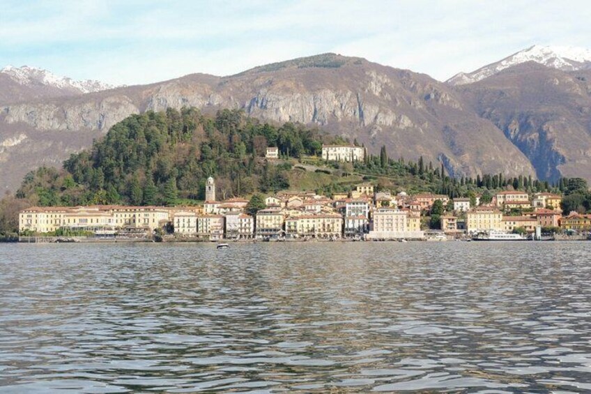 A lakeside town with buildings, a mountain backdrop, and a clear sky. 5
