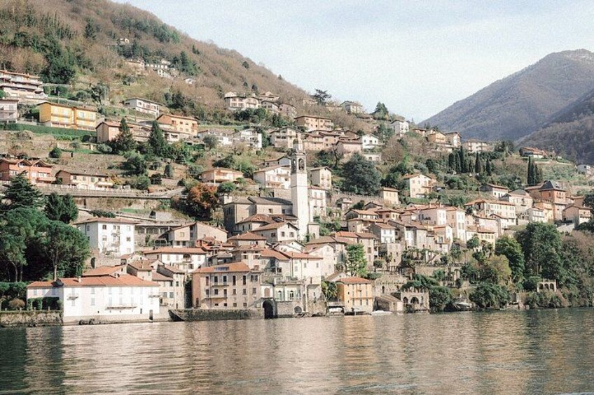 A hillside town with buildings, a church, and a river. 5