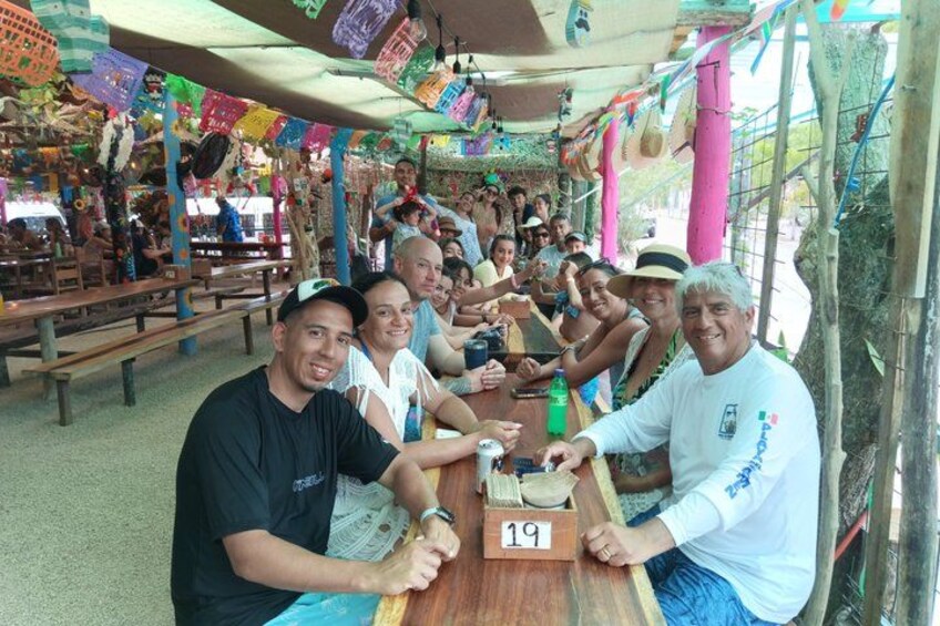 Un groupe de personnes est assis autour d’une table en bois, devant des cartes numérotées, et joue peut-être à un jeu. 2