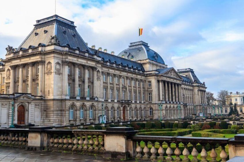 A large, historic building with a prominent dome and columns, surrounded by well-manicured gardens and a formal courtyard. 4