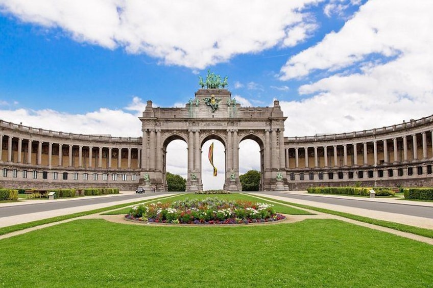 A large, symmetrical building with an ornate archway and a central statue. 1