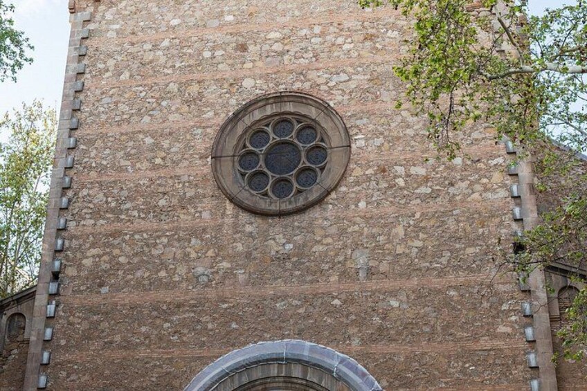 A stone church with a circular window and a stone archway. 2