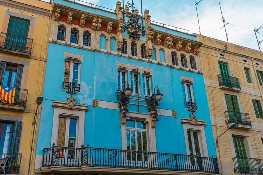 A colorful building with balconies, a decorative facade, and a flag. 5