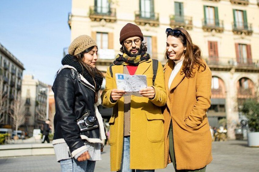 Three people standing on a city street, one holding a map. 4