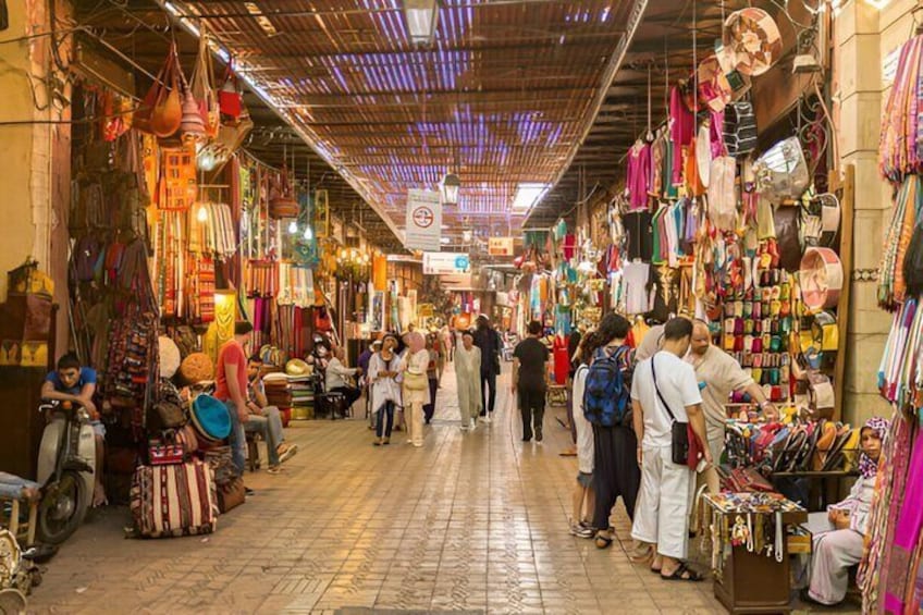 Un mercado interior animado con pasillos estrechos y puestos que venden textiles y bolsos. 2