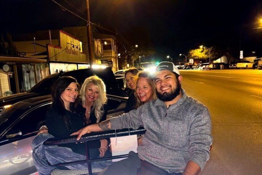 Eine Gruppe von Menschen sitzt nachts in einem Auto auf einer Stadtstraße. 2