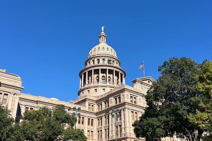 A large, domed building with columns, likely a government or historical building, under a clear blue sky. 2