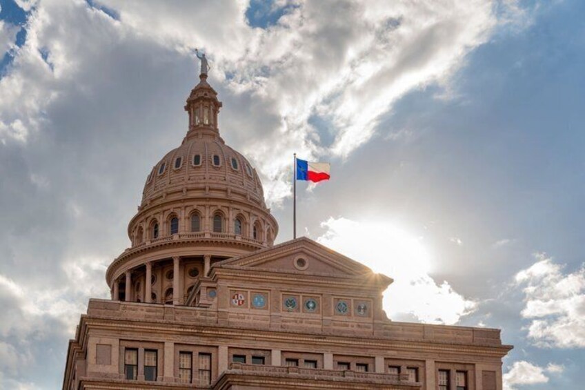A large neoclassical building with a dome and a flag. 4