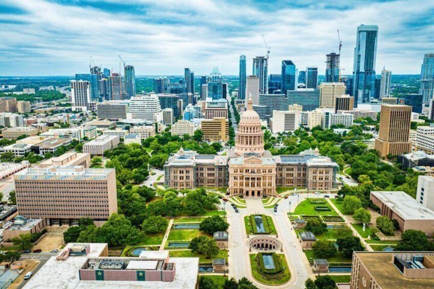 A cityscape with a prominent government building, modern skyscrapers, and a mix of green spaces. 5