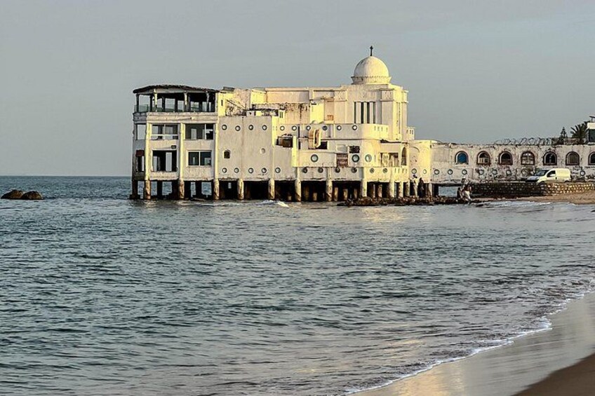 A coastal building with a dome, situated on stilts over the water. 3