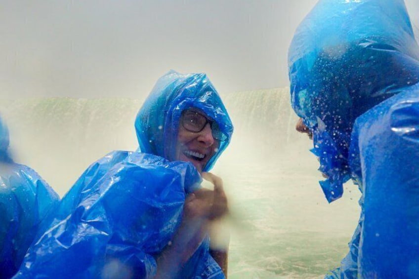 Two people in blue raincoats with water splashing around them. 2