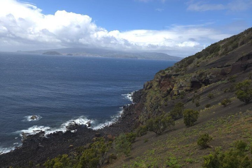 Paisaje costero con acantilados rocosos, olas del océano y vegetación escasa. 4