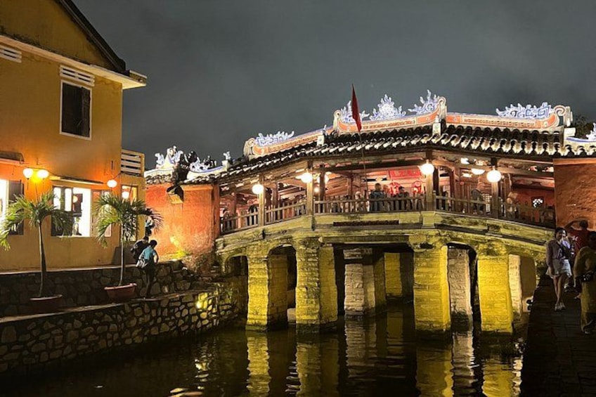 A traditional building with a tiled roof and a stone bridge over water. 5
