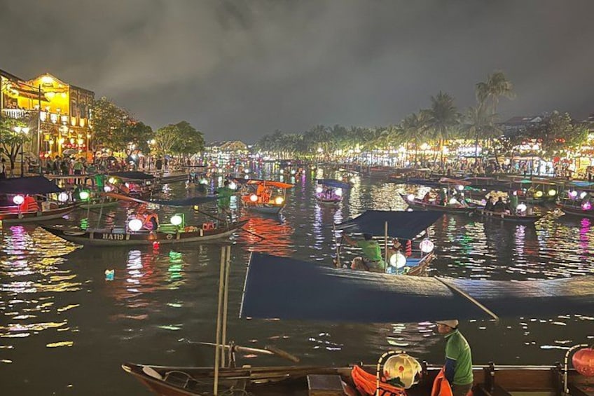 A nighttime river scene with boats and illuminated buildings along the banks. 4