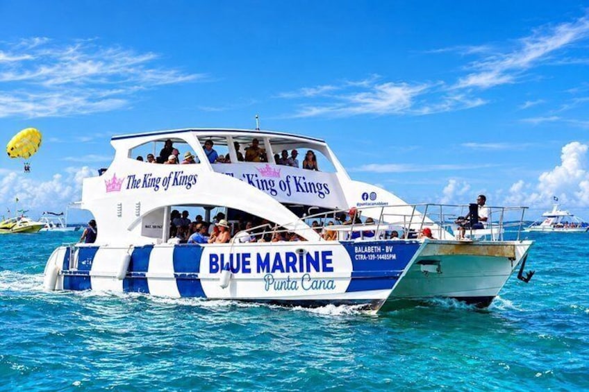 A boat named 'The King of Kings' with 'Blue Marine Punta Cana' written on it, sailing on the water. 1