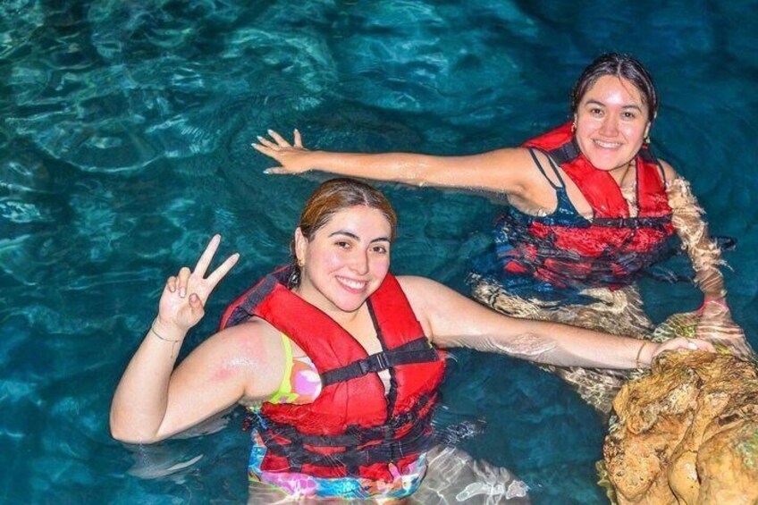 Deux personnes dans une piscine, portant des gilets de sauvetage rouges. 1