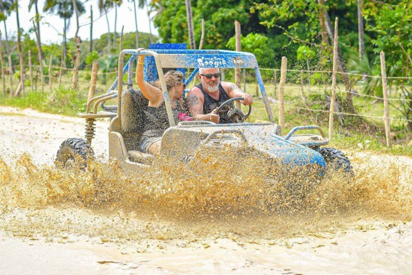 Een voertuig rijdt door een modderig gebied, waarbij water opspat. 5