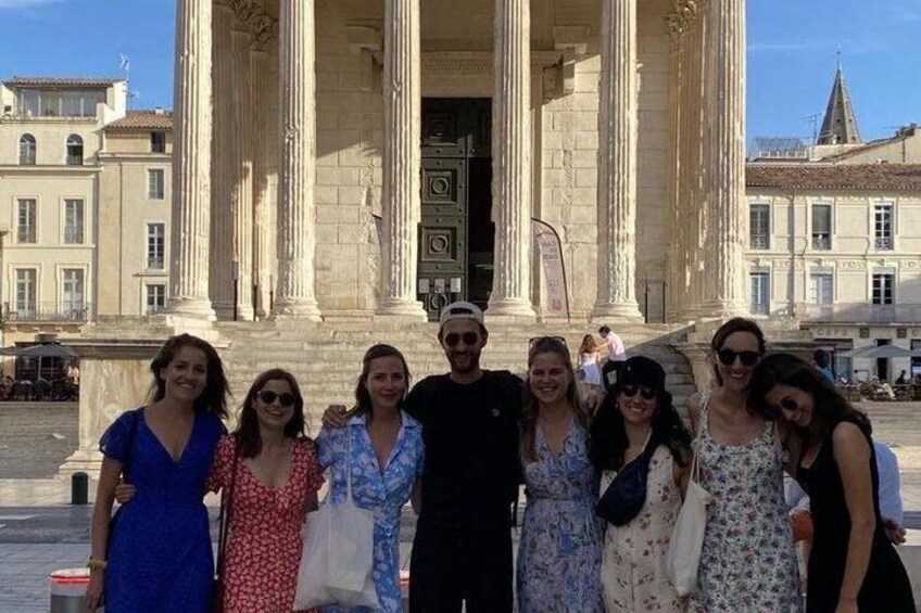 A group of people standing in front of a classical building with columns. 3