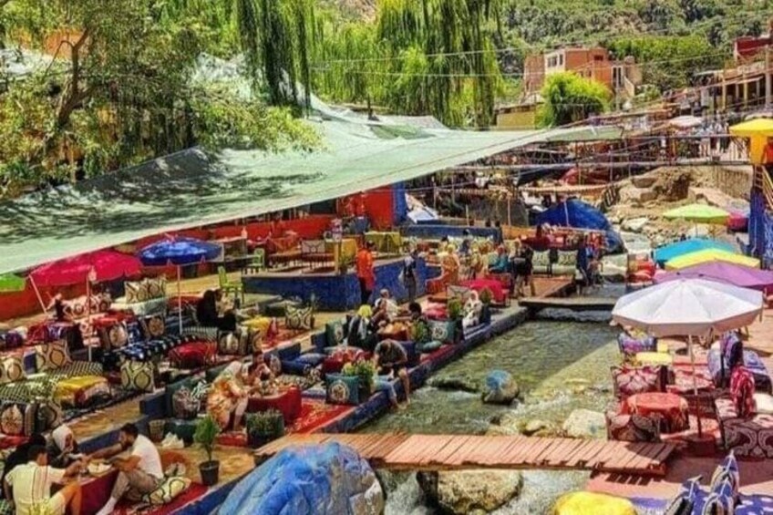 Un mercado al aire libre animado con puestos coloridos y un río al fondo. 2