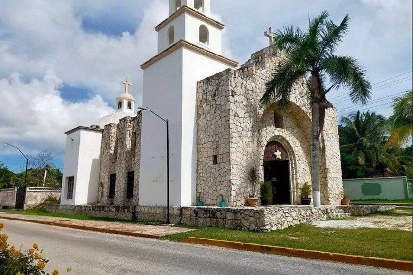 Une église blanche avec une façade en pierre et un clocher. 3