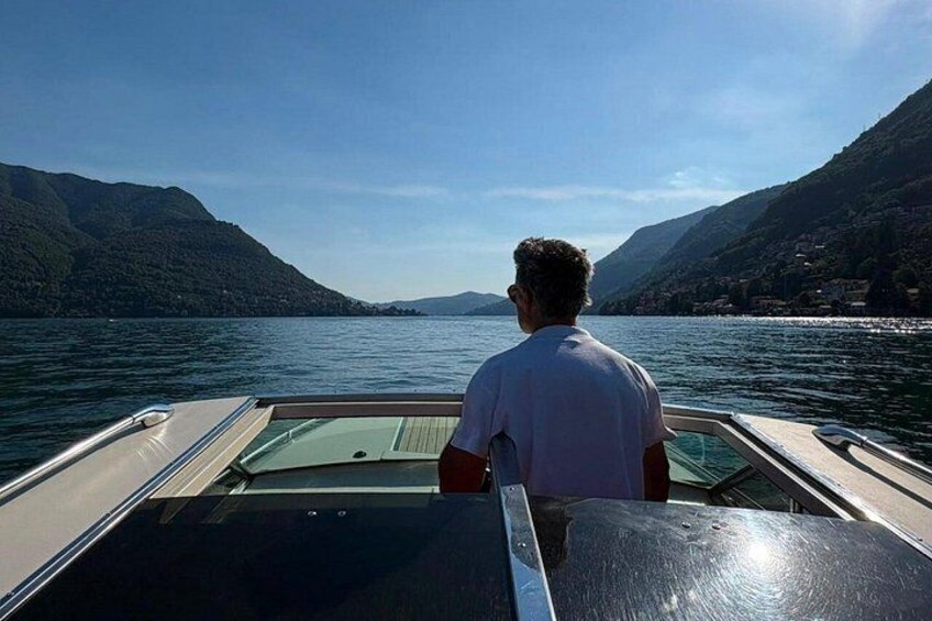 Una persona su una barca con vista su un lago e montagne sullo sfondo. 4
