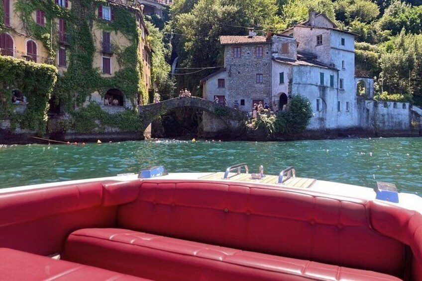 Un bateau rouge sur une rivière, avec des bâtiments et un pont en arrière-plan. 1