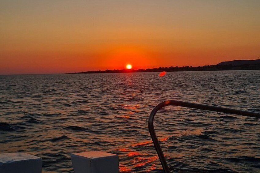 Een zonsondergang boven het water, met een bootrel in de voorgrond. 2