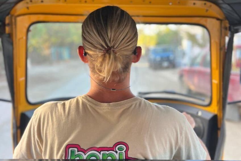 Una persona conduce un auto rickshaw amarillo. 1
