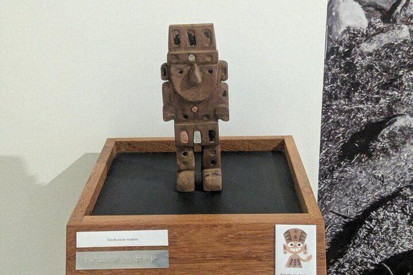 Une sculpture en bois représentant une figure, avec une étiquette indiquant : « Escultura de madre. » 2