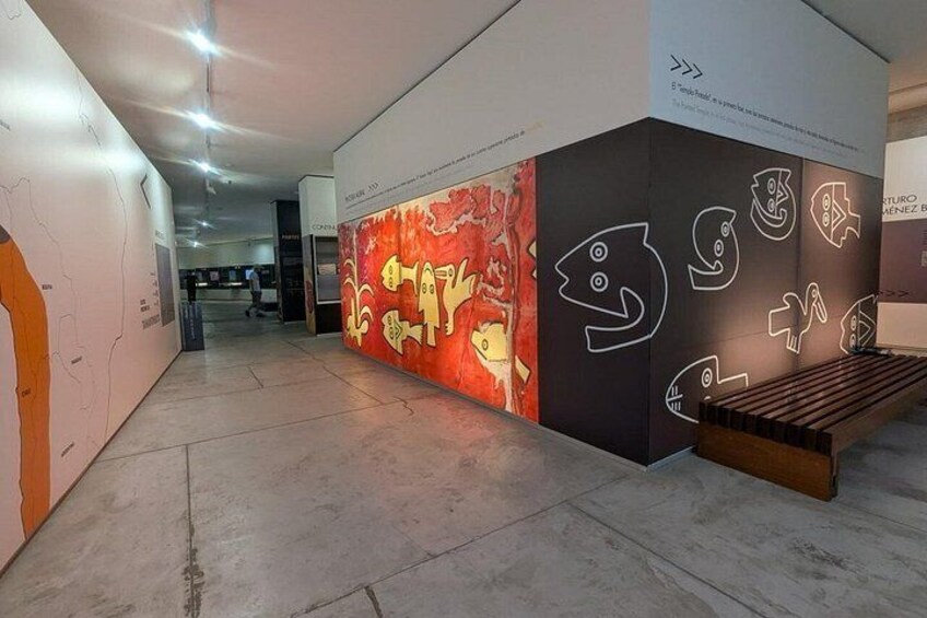 Une galerie d’art intérieure présentant des œuvres abstraites et un banc en bois. 4