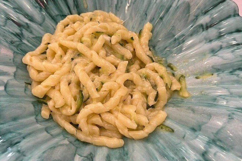 Een bord pasta met romige saus en groene groenten. 4