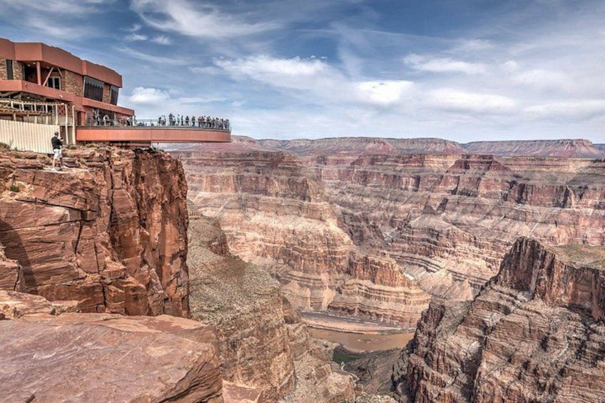 A canyon with layered rock formations and a building with a viewing platform. 2