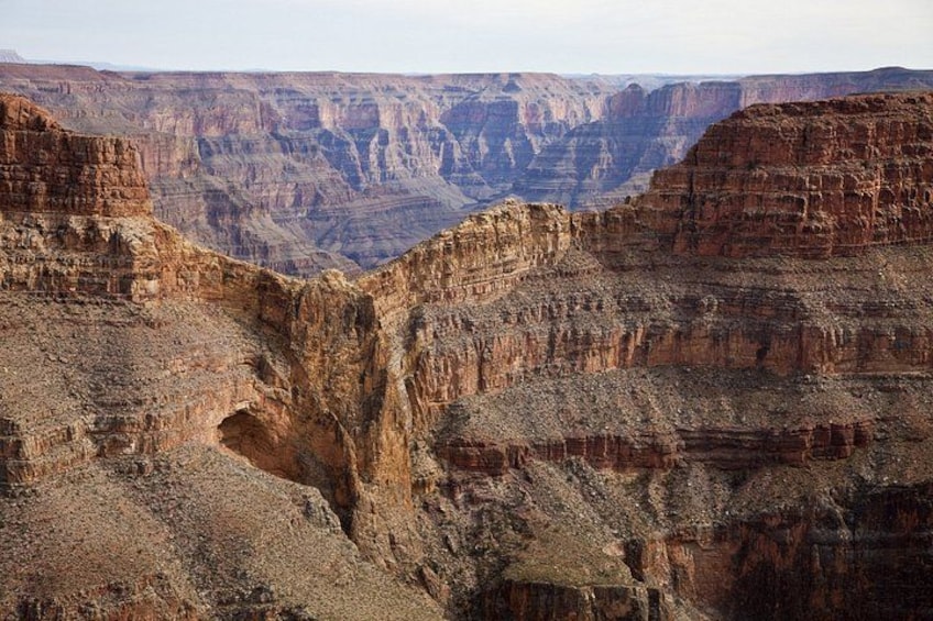 A canyon with layered rock formations and a deep valley. 2