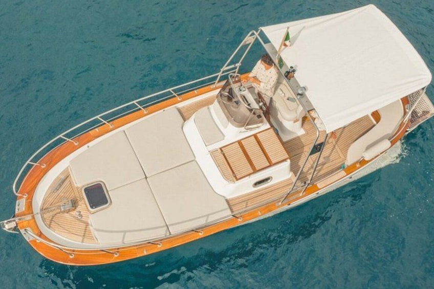 A boat with a covered deck, seating areas, and a small cabin. 1