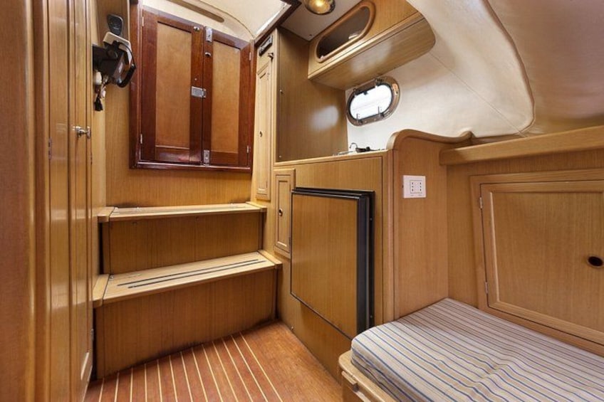 A compact, wooden interior with a bunk bed, a small seating area, and a cabinet. 2